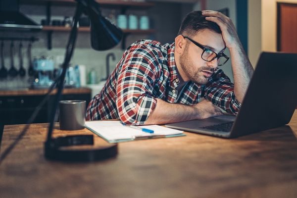 Business owner looking at laptop, stressed