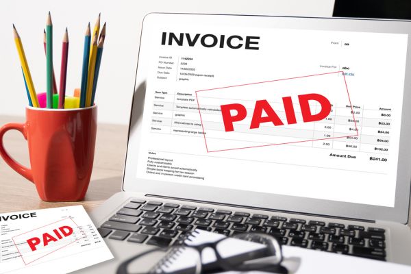 Laptop showing a paid invoice